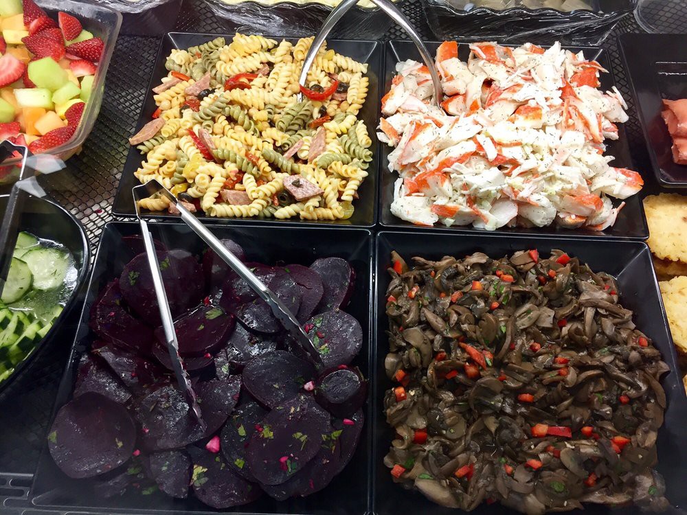 A variety of salads including pasta, potato, beet, and vegetable options at a salad bar.