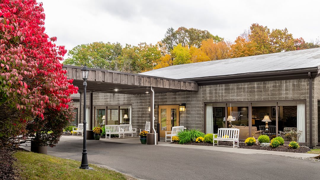 A cozy building with outdoor seating surrounded by autumn trees.
