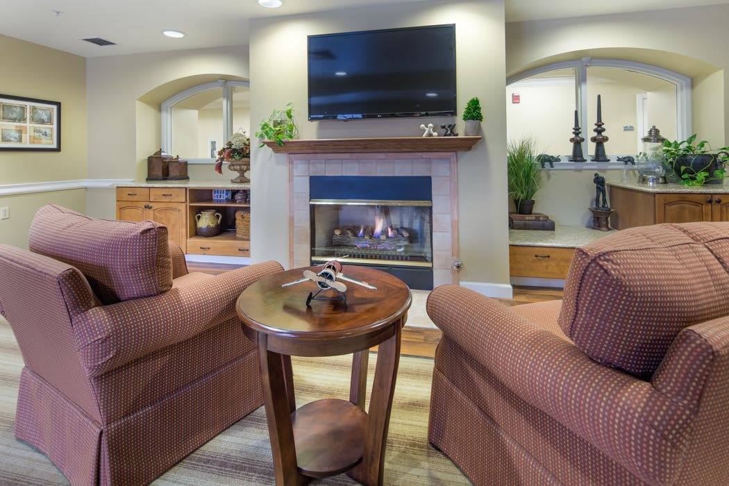 A cozy living room featuring a fireplace, television, and comfortable seating.