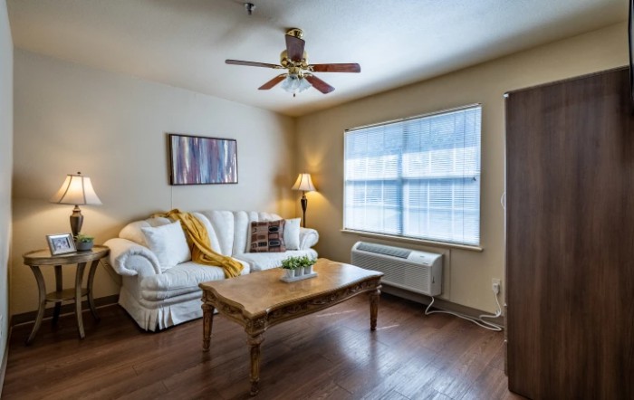 A cozy living room with a sofa, coffee table, and large window.