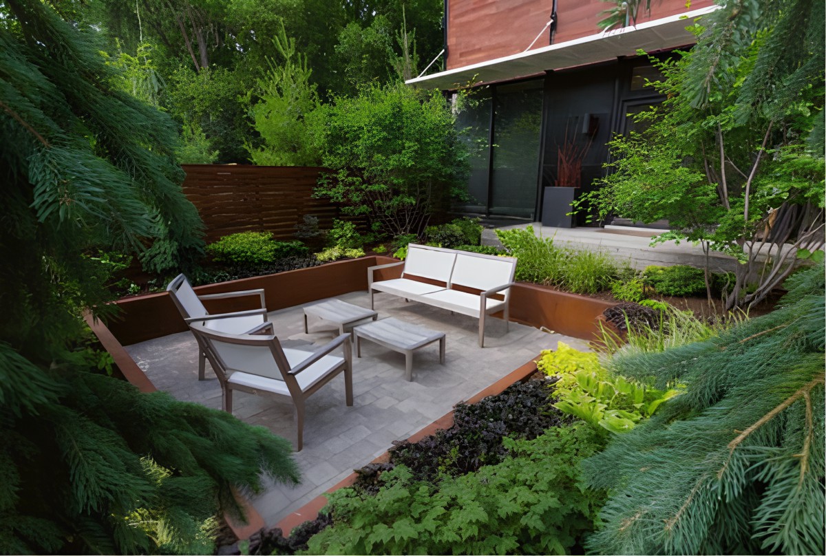 A modern garden patio with comfortable outdoor seating surrounded by lush greenery.