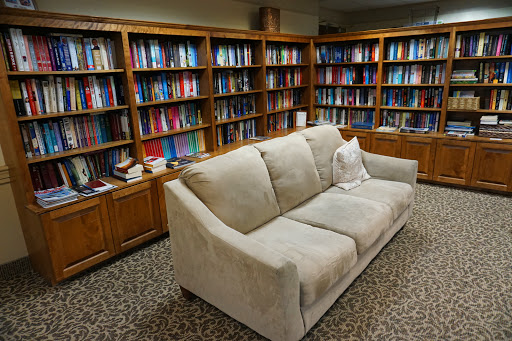 A cozy reading nook featuring a comfortable sofa surrounded by shelves full of books.