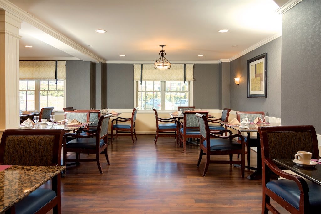 An elegant dining room with neatly arranged tables and chairs, featuring tasteful decor and soft lighting.