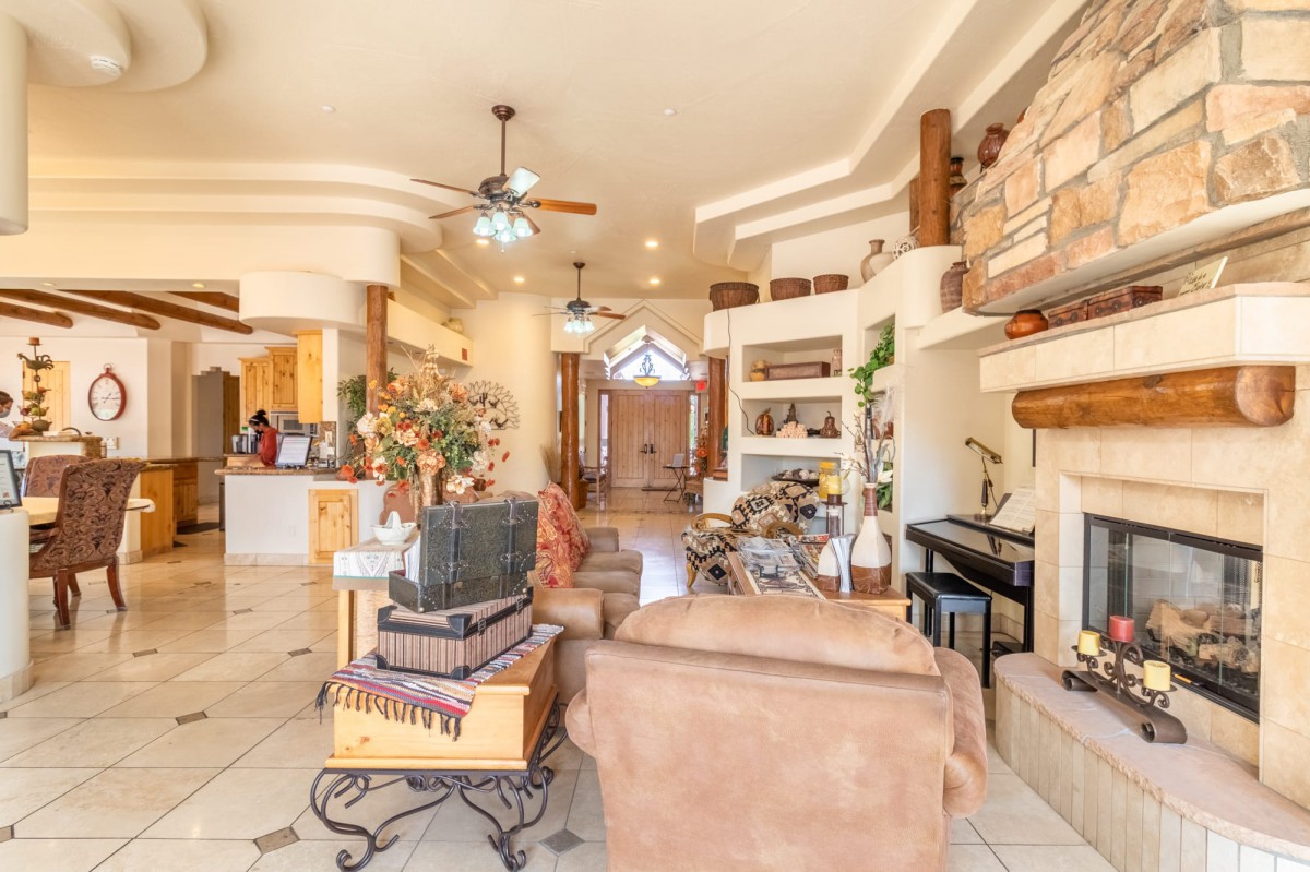 A spacious and elegantly designed living room with comfortable furniture, decorative shelves, and a cozy fireplace.