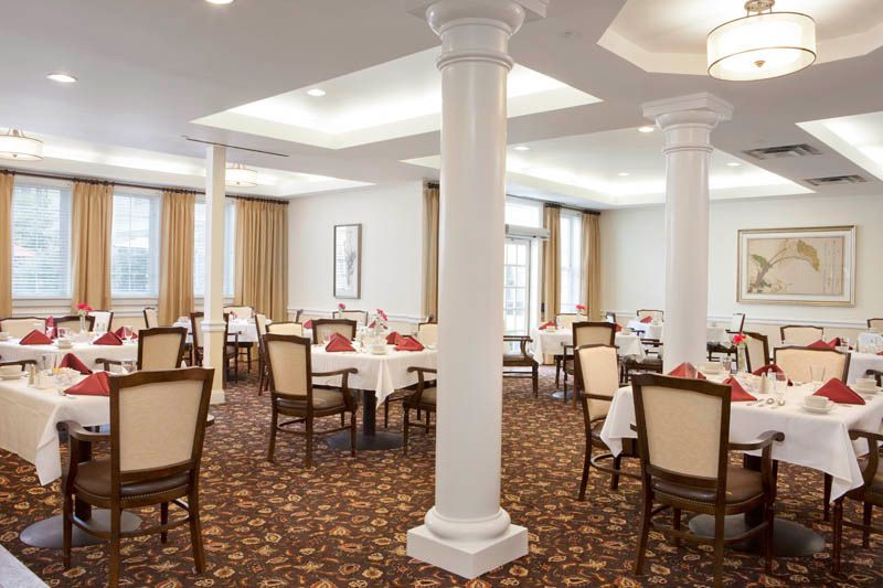 An elegant dining room with neatly arranged tables and chairs, featuring soft lighting and classic decor.