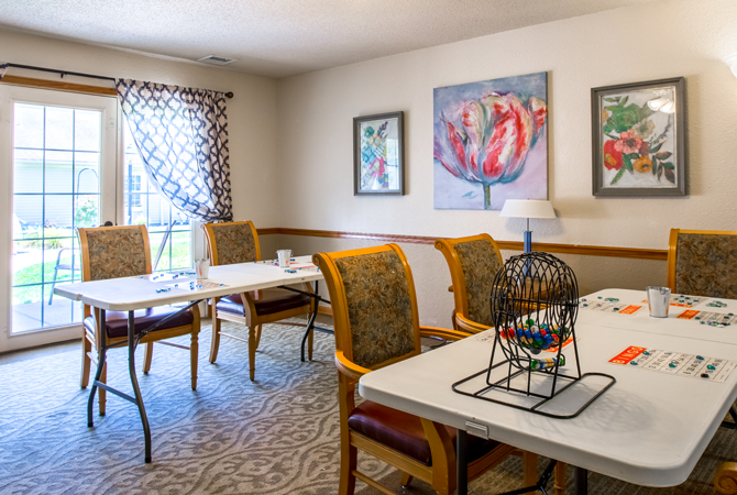 A cozy dining area with elegant chairs and tables, adorned with floral artwork on the walls.