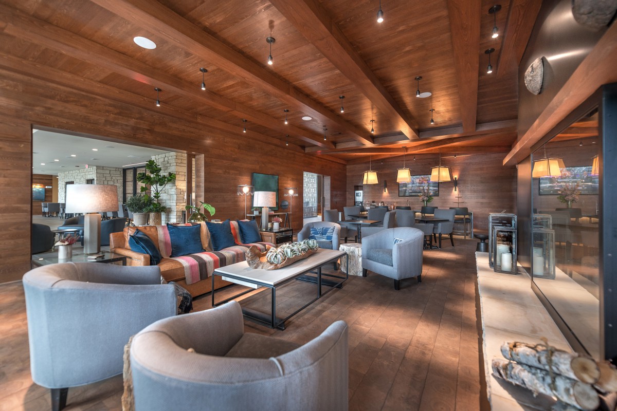 A modern and cozy living room with stylish furniture and a wooden ceiling.