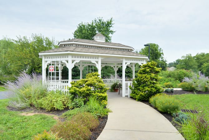 A scenic gazebo with surrounding greenery and a curved pathway.