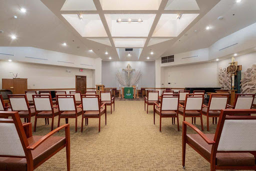 A spacious and well-lit worship room with neatly arranged chairs.