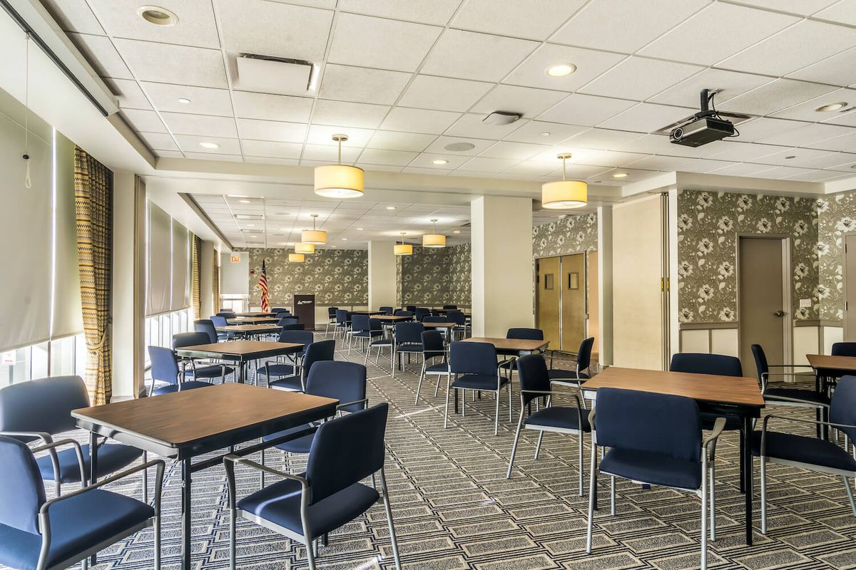 A modern conference room with neatly arranged tables and chairs, featuring a stylish decor.