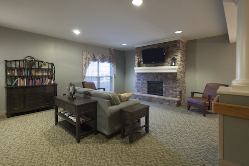 A cozy living room featuring a stone fireplace and comfortable seating.