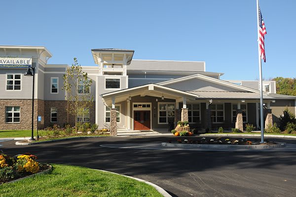 A modern residential building with a landscaped entrance on a sunny day.