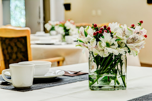 A beautifully arranged table featuring a floral centerpiece and coffee cups, perfect for a cozy dining experience.