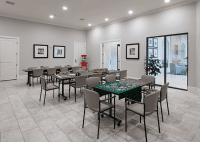 A modern meeting room with several tables and chairs arranged neatly under bright lighting.