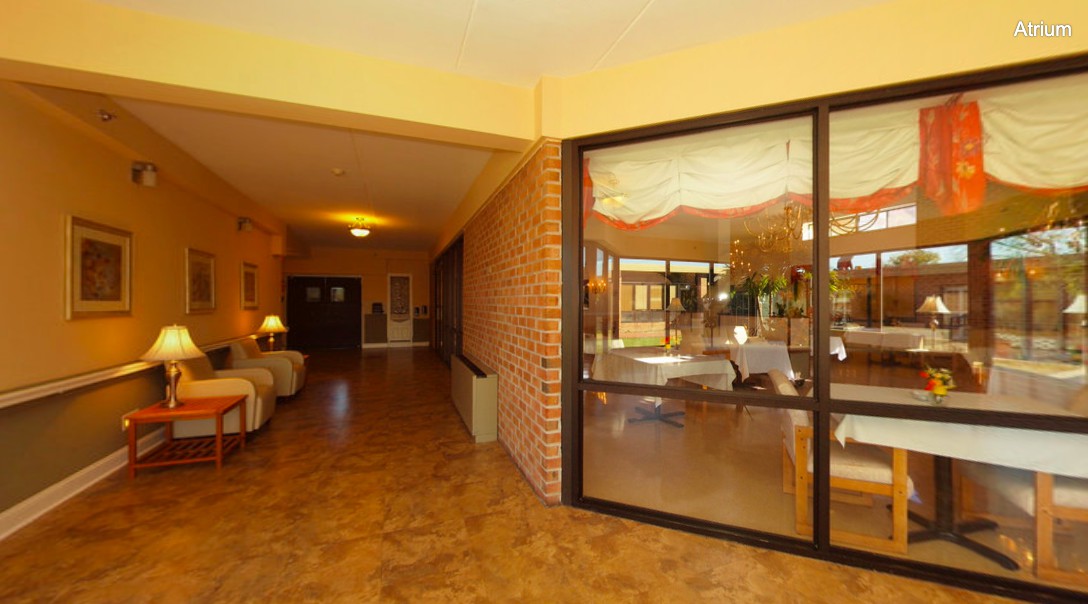 A welcoming hallway with a seating area and large glass windows.