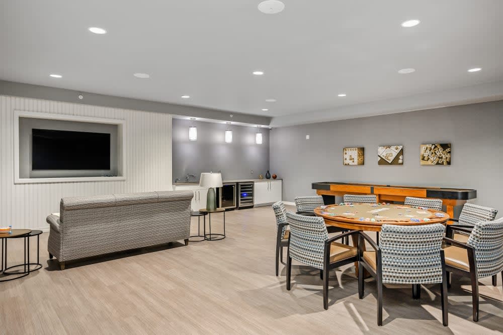 A modern and minimalist living room with a TV, seating area, and dining table.