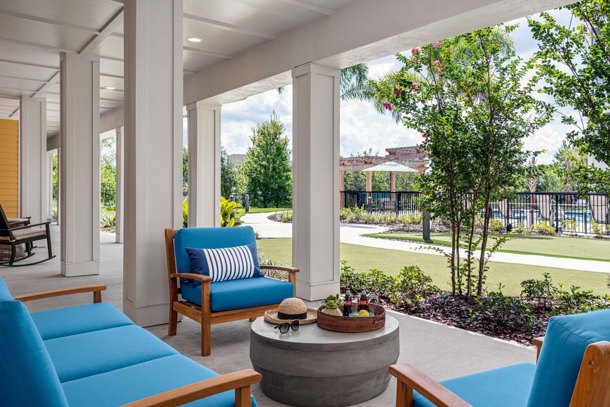 A cozy patio area with blue-cushioned chairs, offering a scenic garden view.