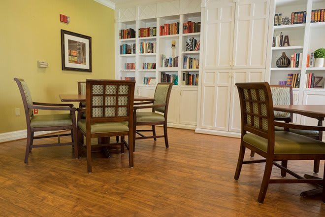 A cozy reading area featuring a table and chairs surrounded by bookshelves.