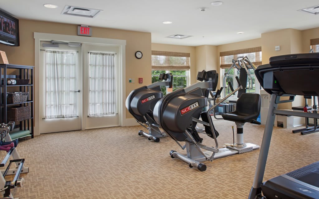 A modern fitness room equipped with exercise machines and cardio equipment.
