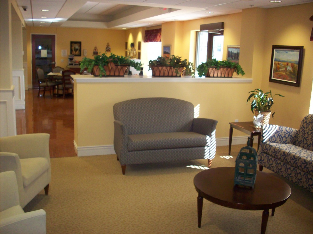 A cozy living room with a sofa and coffee table, accented by plants and warm lighting.