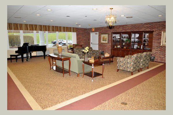 A cozy living room with a piano, comfortable seating, and elegant decor.