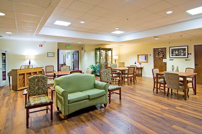 A warmly lit lounge area with comfortable seating and wooden flooring.