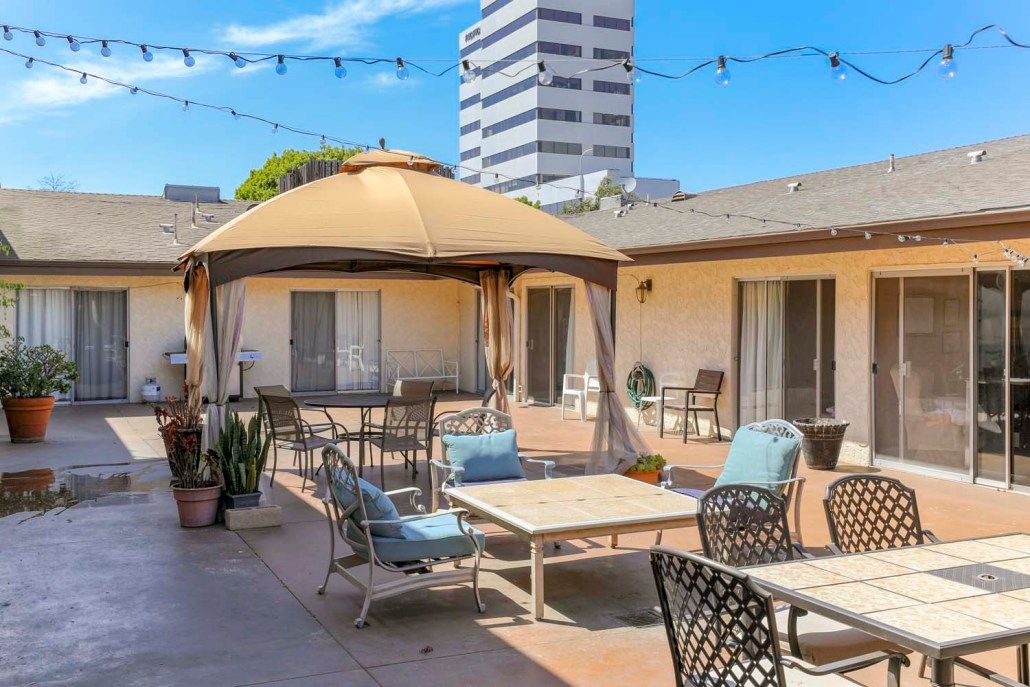A cozy outdoor patio setup with comfortable seating and a gazebo, located in an urban area.