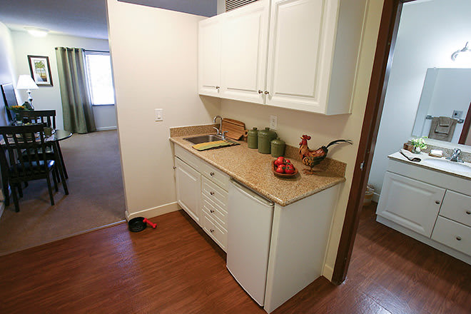 A small kitchen area with white cabinets, a countertop, and decorative items.