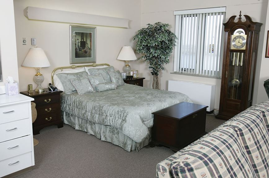 A cozy bedroom with a neatly made bed and stylish decor.