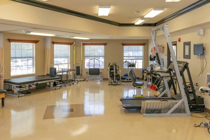 A spacious gym with various exercise equipment and workout stations.