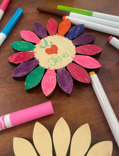 A vibrant handmade flower craft using colored markers and materials.