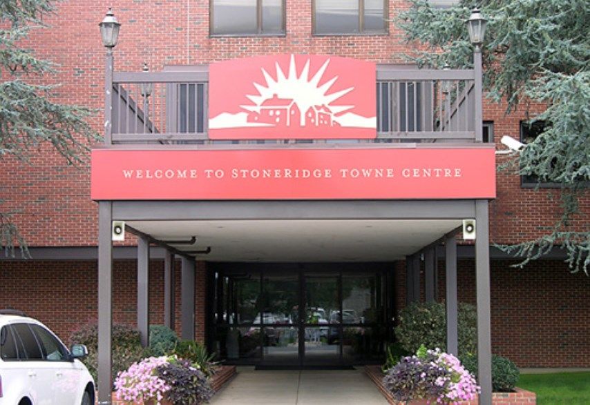 Entrance to a building with a welcome sign and decorative flowers.