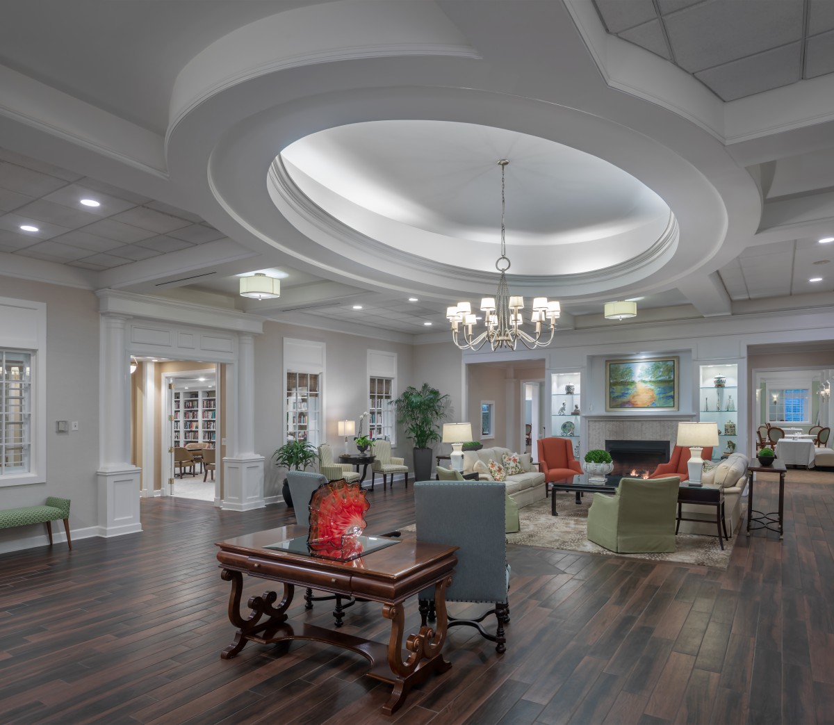 A modern lobby with elegant furnishings and a central chandelier.