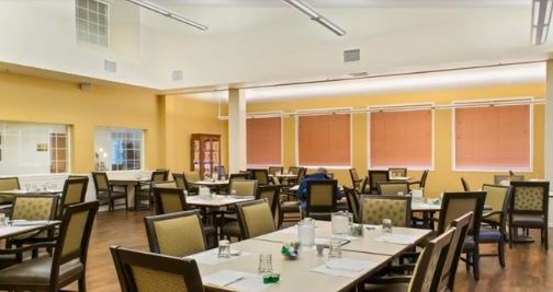 An empty dining room with tables and chairs arranged neatly.
