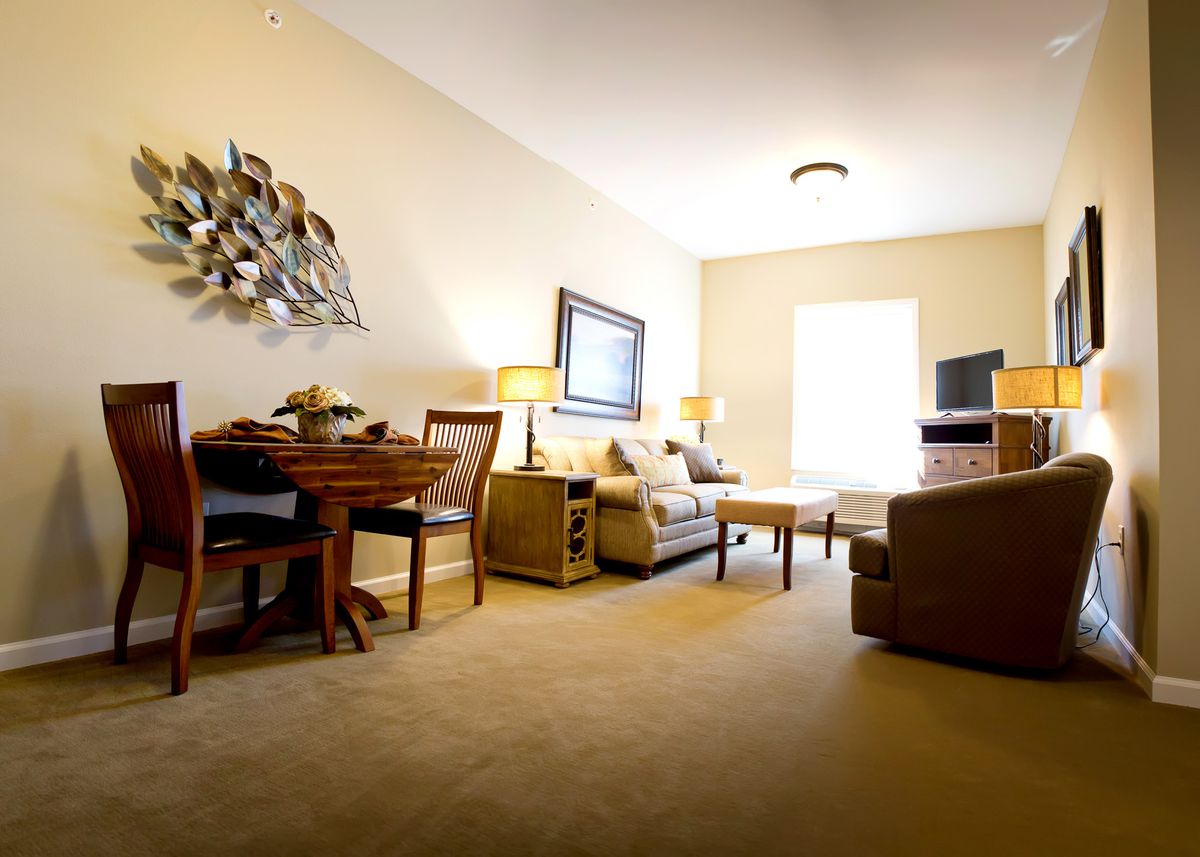A cozy living room featuring a comfortable sofa, a dining table, and a television.
