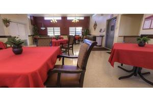 A cozy dining area with red tablecloths and neatly arranged chairs.