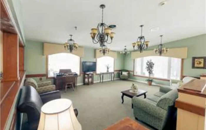 A cozy living room with elegant chandeliers and large windows.