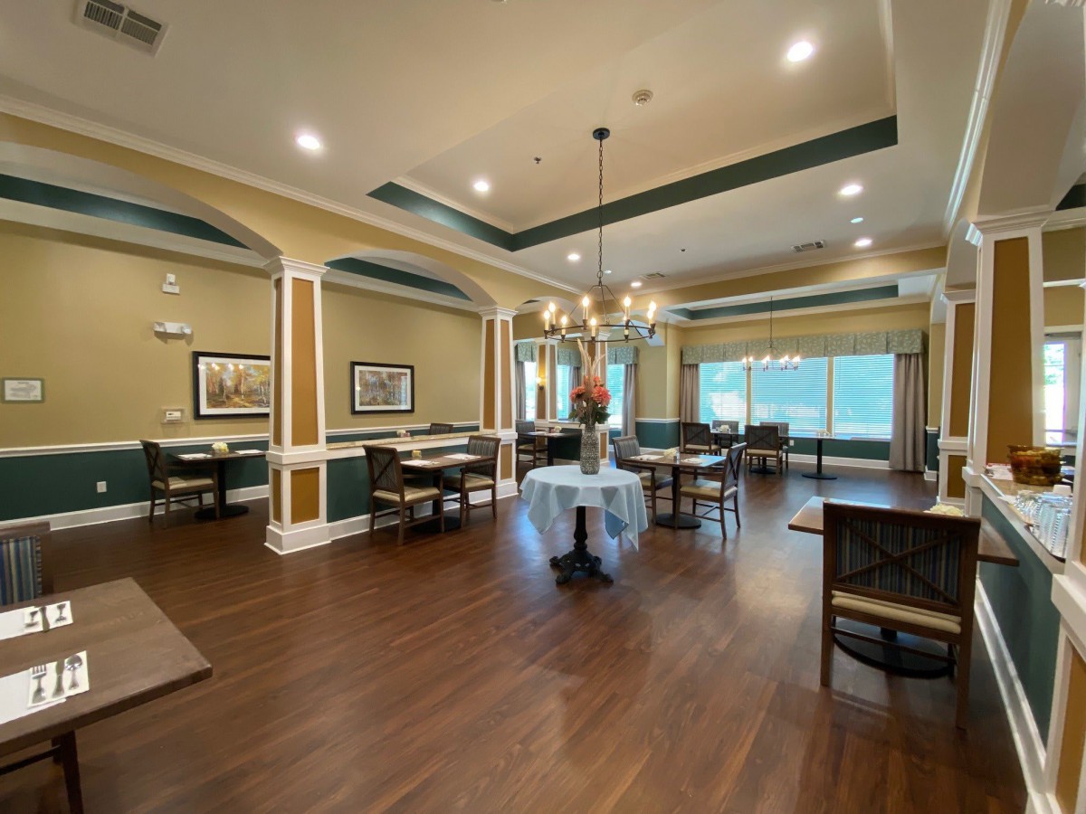 An elegant dining room with wooden floors and chandeliers.