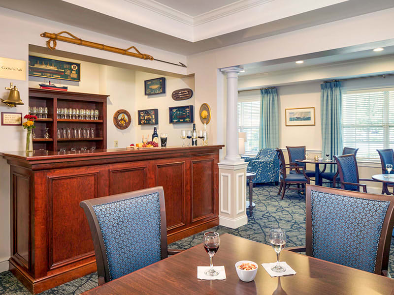 A cozy and traditional bar interior with wooden furnishings and a seating area.