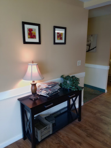 A cozy entryway featuring a small table with decorative items and framed artwork.