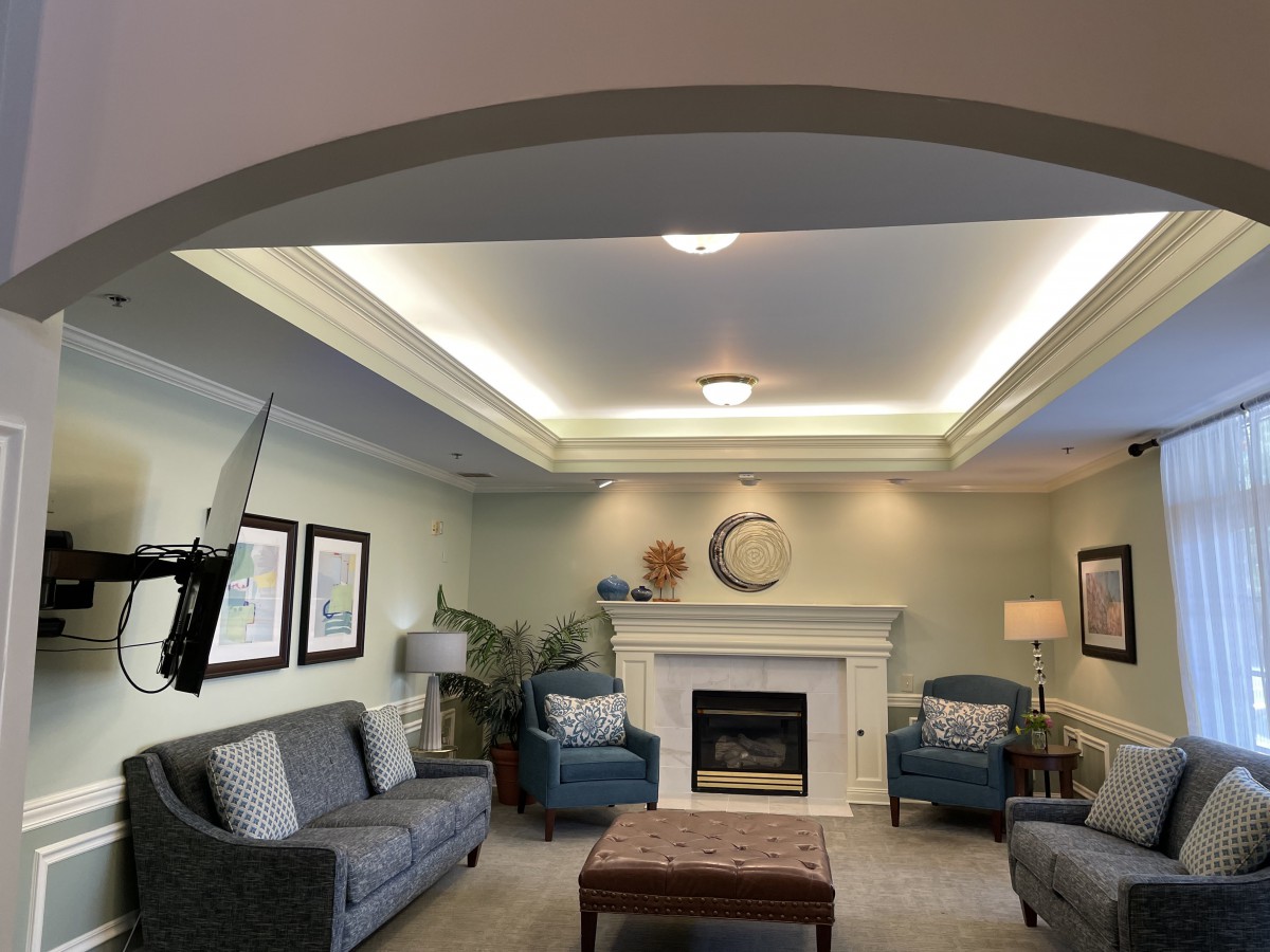 A cozy living room featuring comfortable sofas, a fireplace, and elegant lighting.