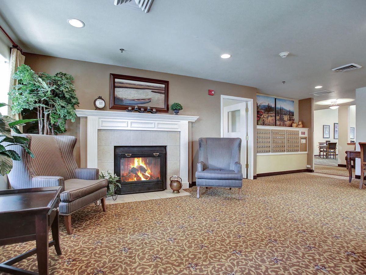 A cozy living room with a fireplace, comfortable chairs, and stylish decor.