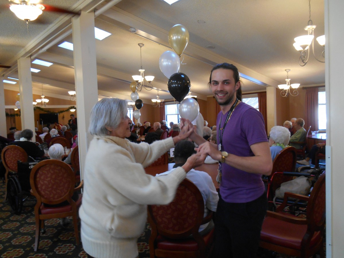 A joyful gathering where two people exchange balloons during a celebration.