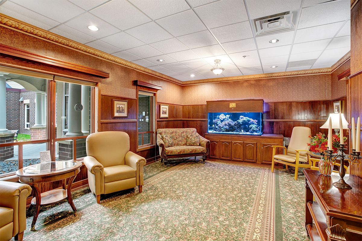 A cozy waiting room featuring comfortable seating and a large aquarium.