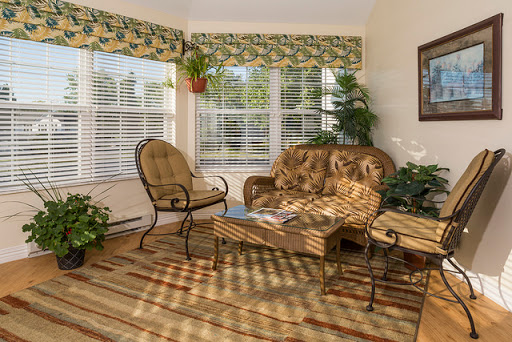 A cozy living room adorned with plants and natural light, featuring comfortable seating and a welcoming atmosphere.
