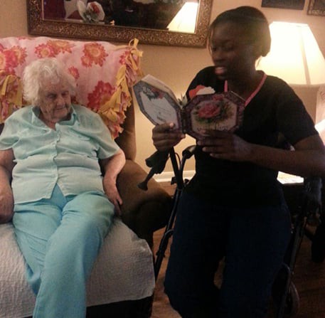 A caregiver spending quality time with an elderly woman in a nursing home setting.