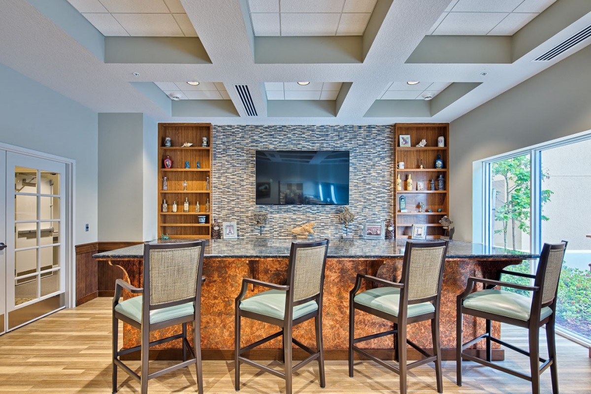 Modern bar area with stylish seating and a large television.