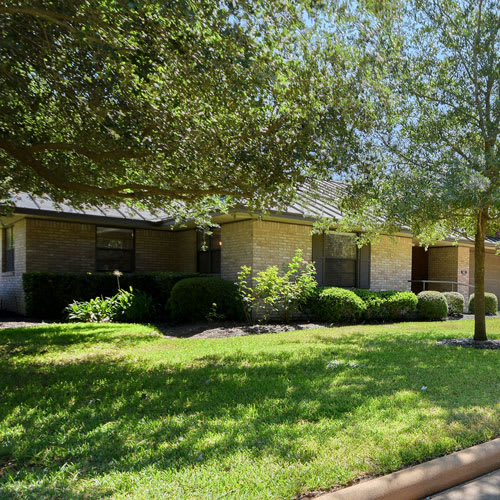 A sunny day in a suburban neighborhood with a well-maintained lawn and trees.