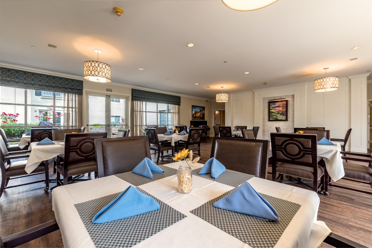 A well-appointed restaurant dining area with neatly arranged tables and blue napkins.