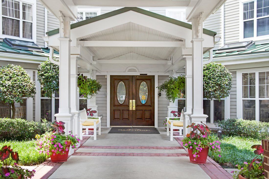 A charming porch entrance with potted plants and wooden doors.